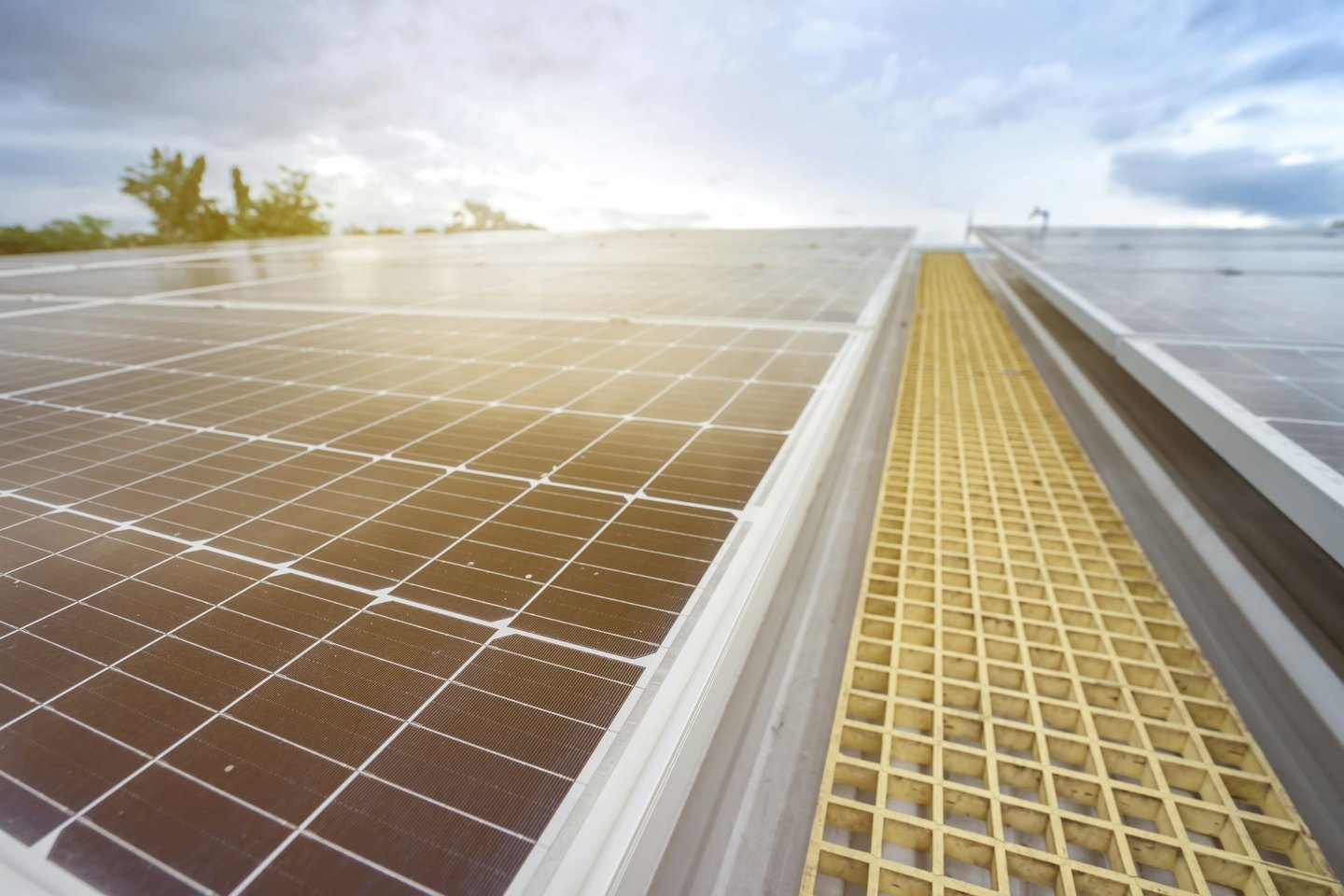 Solar panels installed on a rooftop with a yellow walkway.