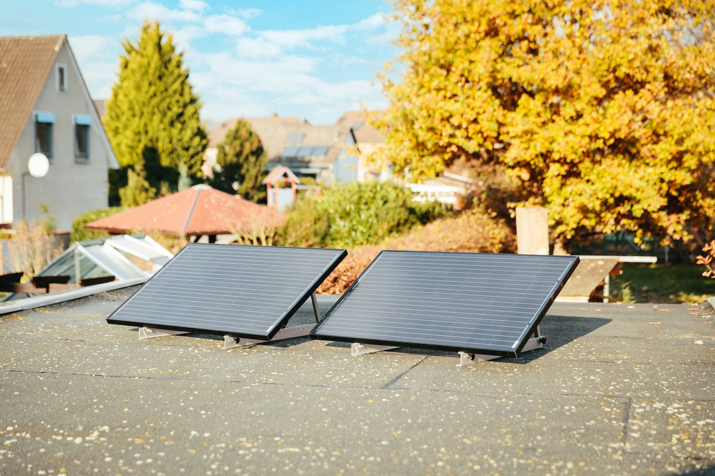 Two solar panels on a rooftop under bright sunshine.